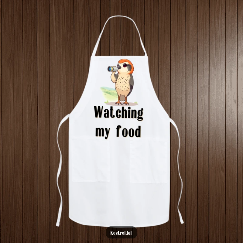 Funny kestrel apron with a curious bird using tiny binoculars to scan a landscape. Humorous and practical kitchen wear.