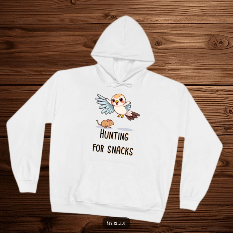 Funny hoodie depicting a cartoon kestrel comically swooping down with outstretched wings, in pursuit of a tiny mouse.