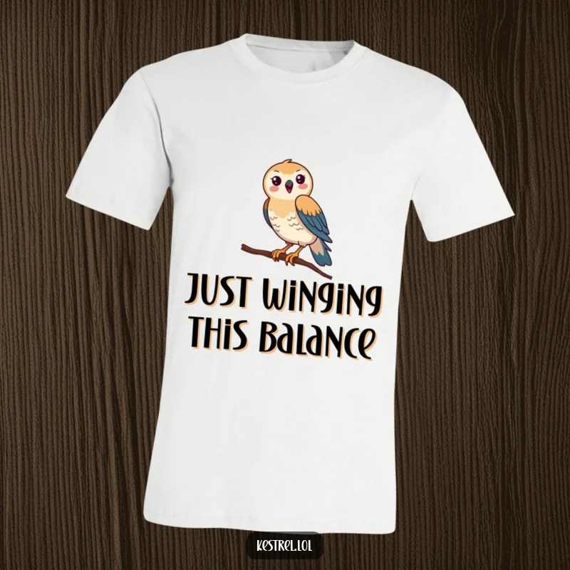 Funny Kestrel T-Shirt: A happy kestrel comically attempts to balance on a tiny branch, showcasing its unsteady and humorous struggle.