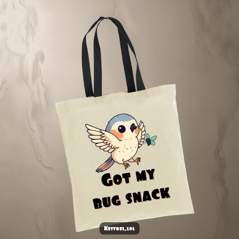 Funny kestrel tote bag illustrating a bird catching a bug mid-flight, a humorous and practical accessory for bird lovers.