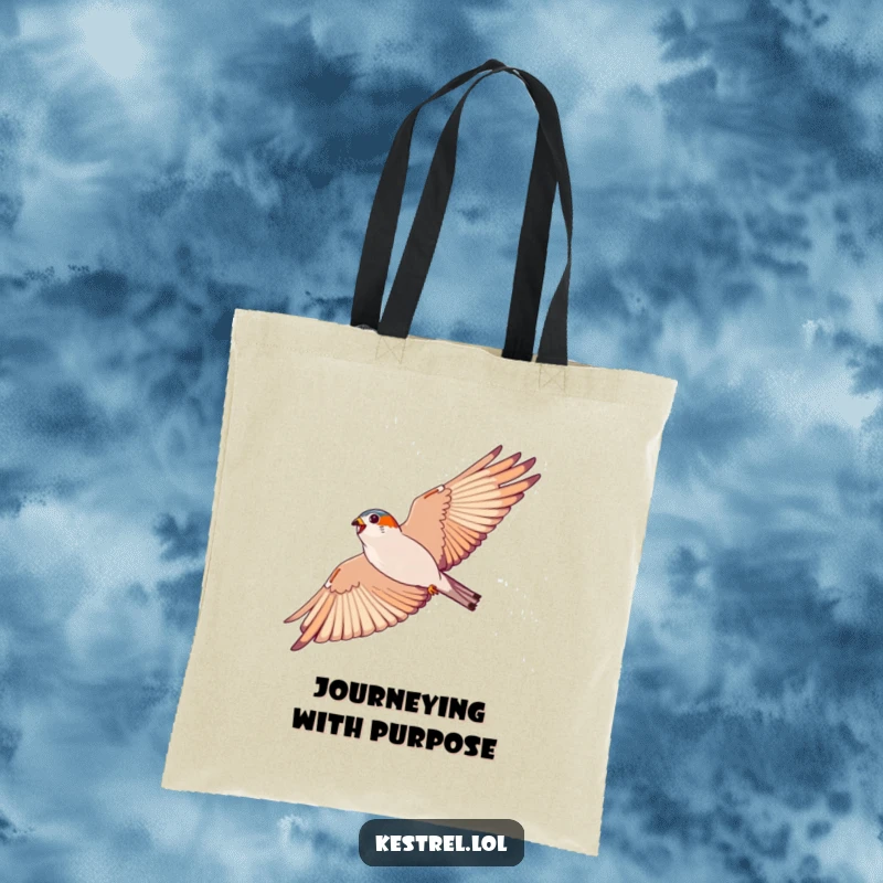 Funny kestrel tote bag, featuring an energetic bird soaring in a wide arc against a blue sky; a stylish accessory.
