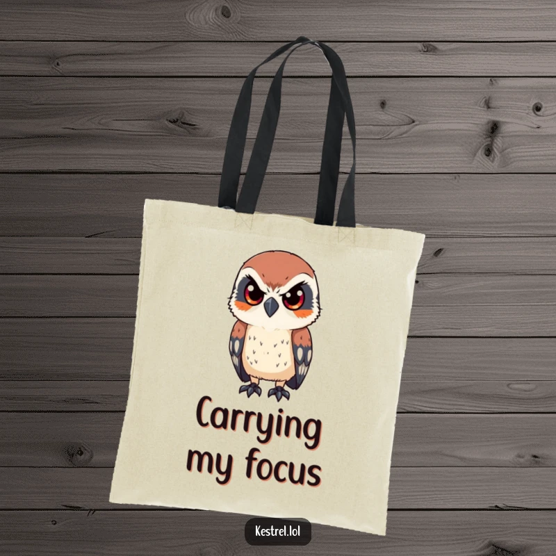 Funny tote bag with a kestrel character looking intently with sharp, focused eyes, practical with humorous bird-lover charm.